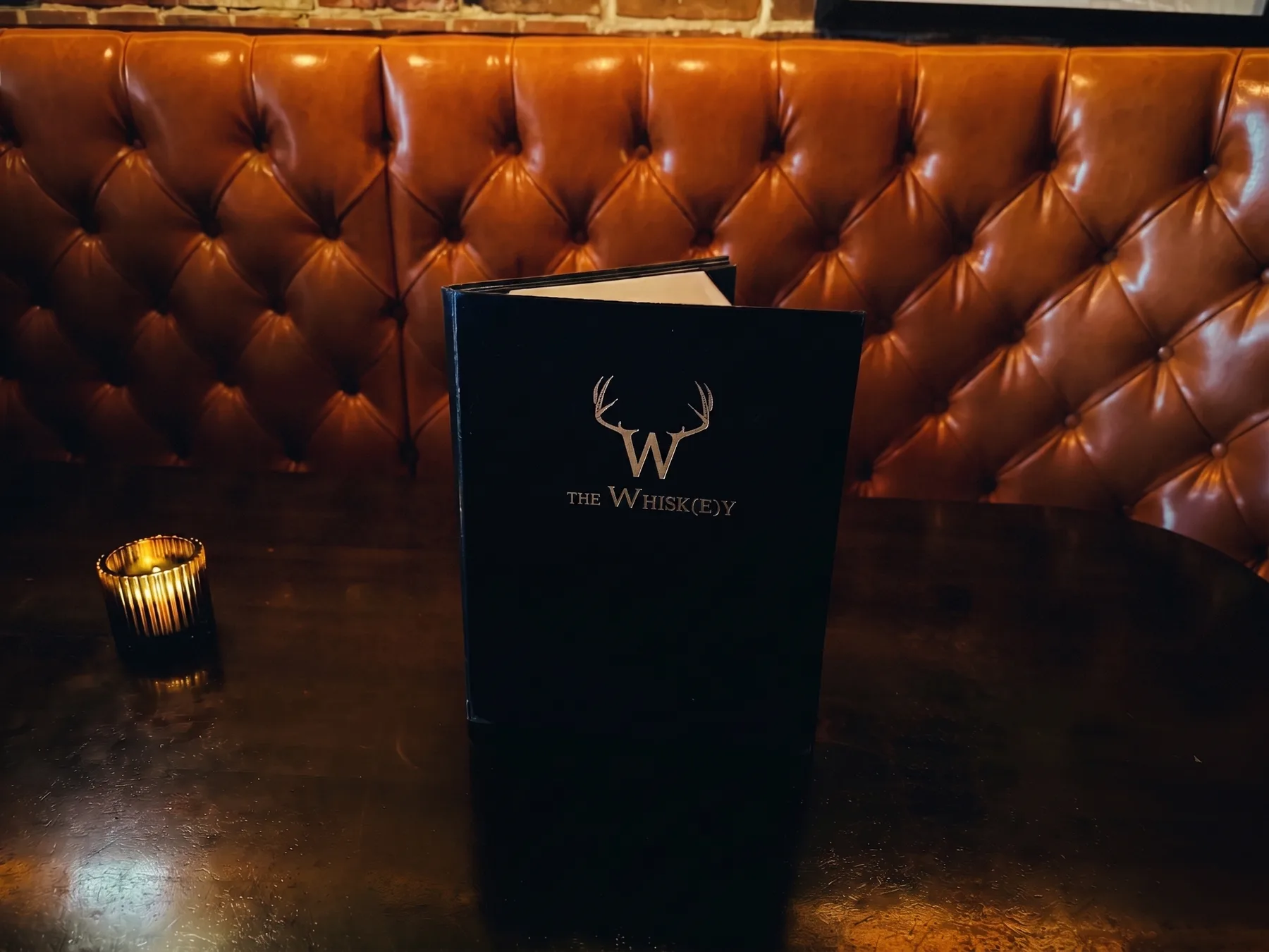 Menu and candle on a booth table
